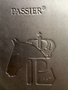 Passier Optimum Pony Dressage har sit eget logo på sadelklappen. Logo sammenfatter Passiers historik og vision.